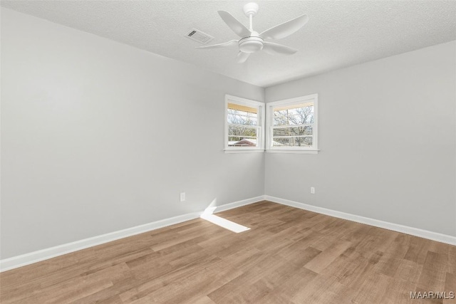 unfurnished room with ceiling fan, light hardwood / wood-style floors, and a textured ceiling