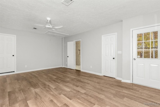 unfurnished room featuring light hardwood / wood-style floors, a textured ceiling, and ceiling fan