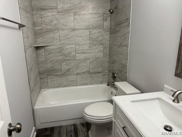 full bathroom with wood-type flooring, toilet, vanity, and tiled shower / bath