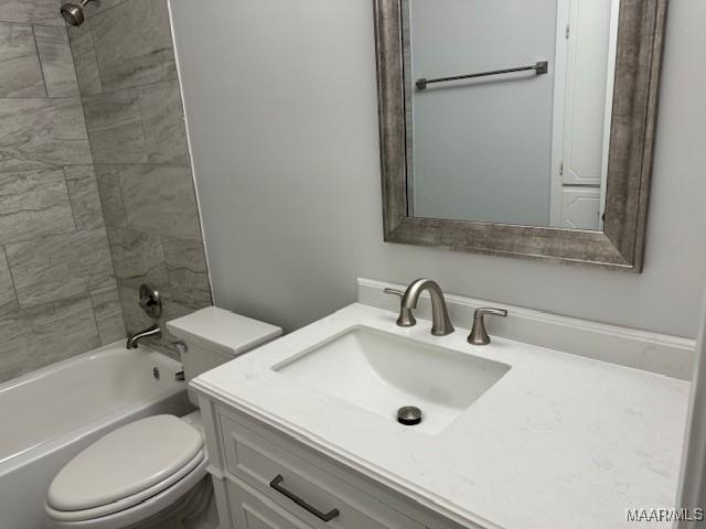 full bathroom with toilet, tiled shower / bath, and vanity