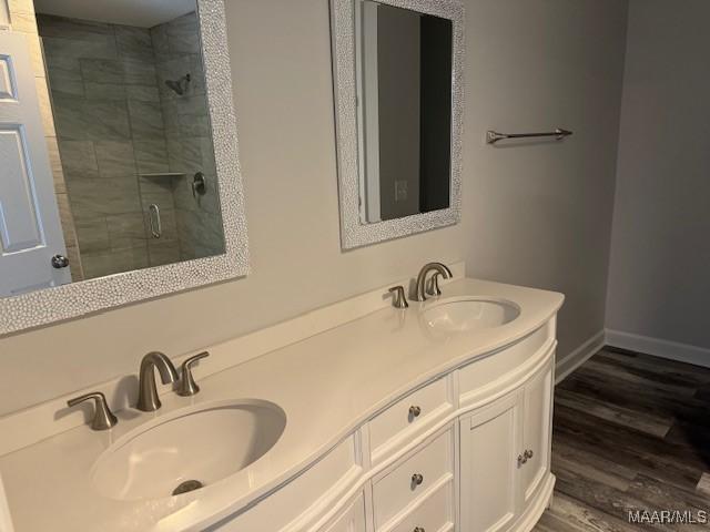 bathroom featuring hardwood / wood-style flooring, a shower with door, and vanity