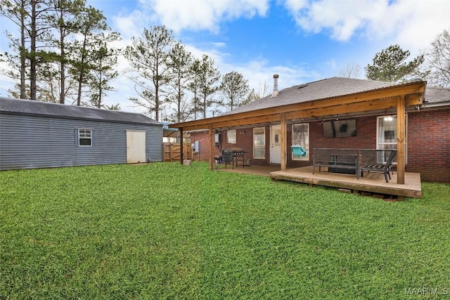 back of property with a wooden deck, a lawn, and a storage shed