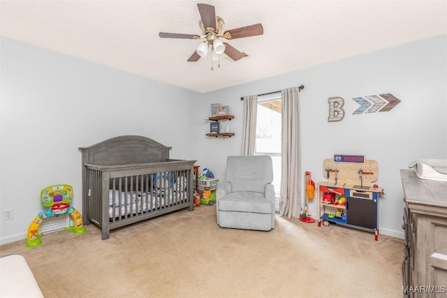 bedroom with ceiling fan, carpet flooring, and a crib