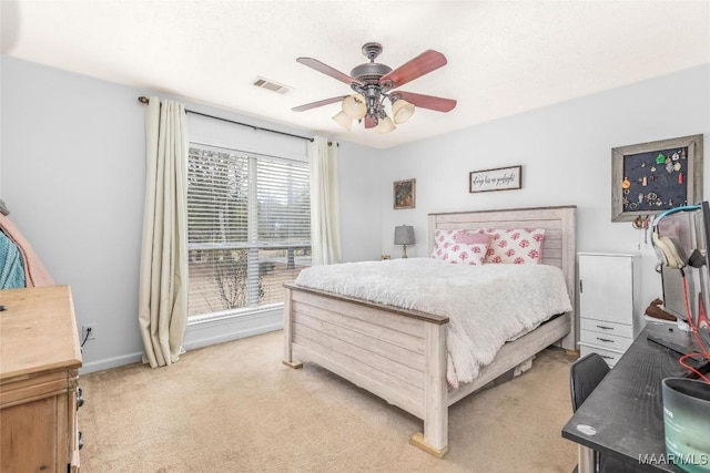 bedroom with ceiling fan, light carpet, and multiple windows