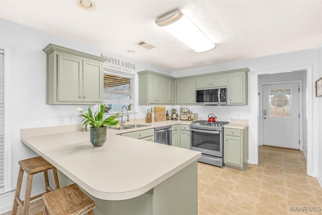 kitchen with sink, a kitchen breakfast bar, stainless steel appliances, and kitchen peninsula