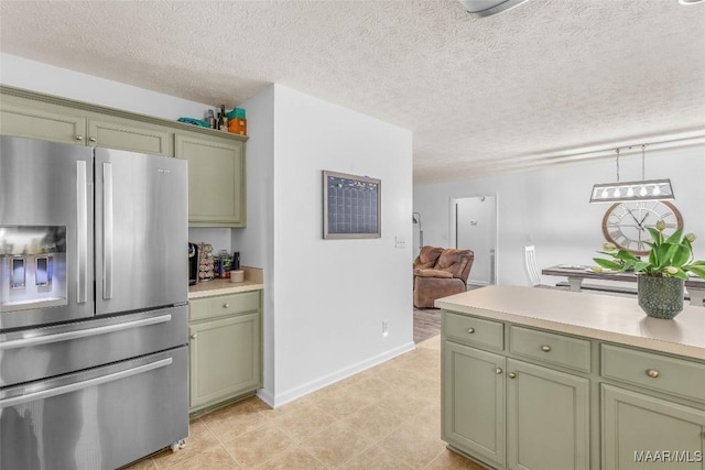 kitchen with stainless steel fridge with ice dispenser, a textured ceiling, and green cabinetry