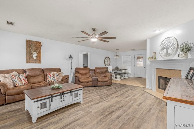 living room featuring ceiling fan and light hardwood / wood-style flooring