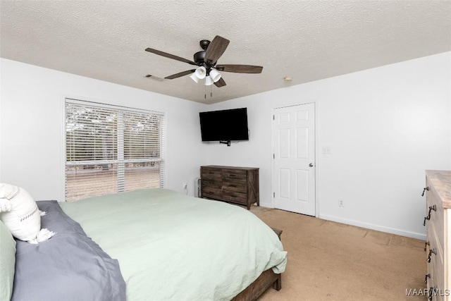 carpeted bedroom featuring a textured ceiling and ceiling fan