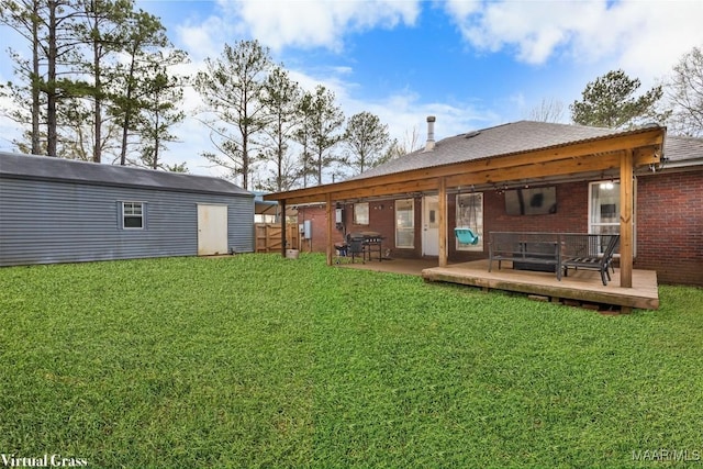 rear view of property with a storage shed, a lawn, and a deck