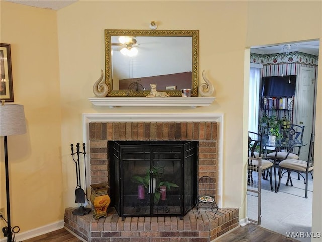 interior details featuring a brick fireplace and hardwood / wood-style flooring