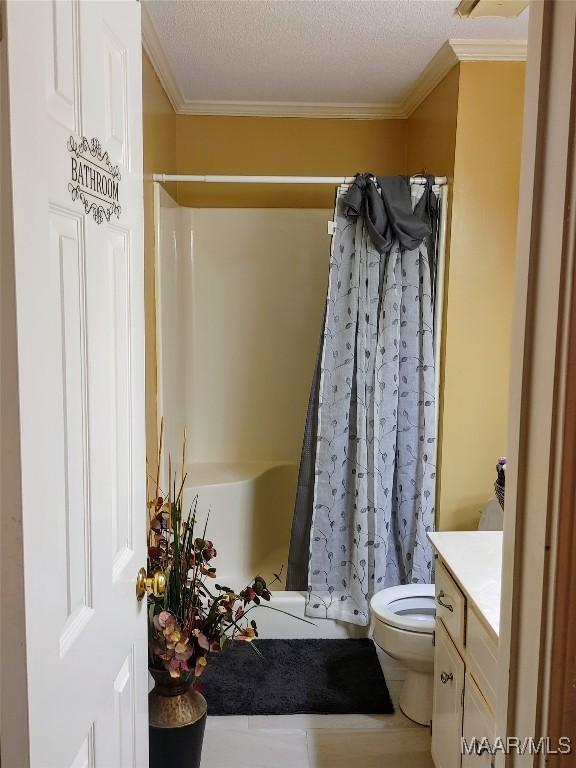 bathroom featuring a textured ceiling, vanity, a shower with curtain, toilet, and crown molding