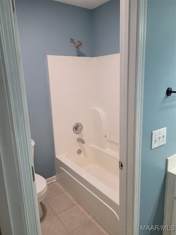 bathroom featuring toilet, bathtub / shower combination, and tile patterned floors