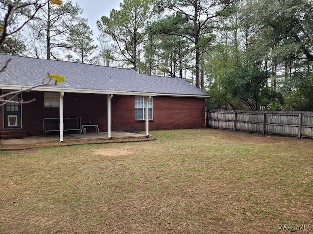 back of house with a lawn and a patio