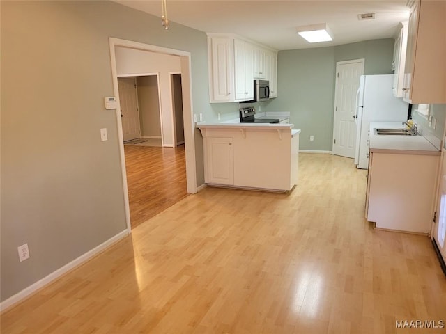 kitchen featuring light hardwood / wood-style floors, kitchen peninsula, white cabinetry, appliances with stainless steel finishes, and a kitchen breakfast bar