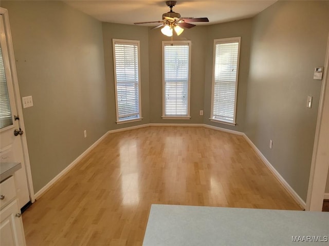 unfurnished dining area featuring ceiling fan and light hardwood / wood-style floors