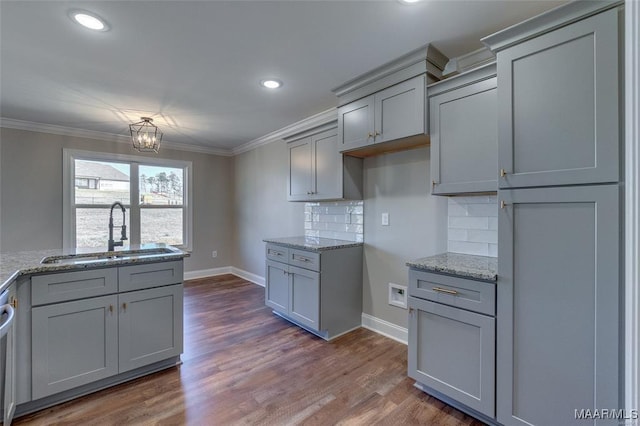 kitchen featuring tasteful backsplash, sink, light stone counters, and gray cabinetry