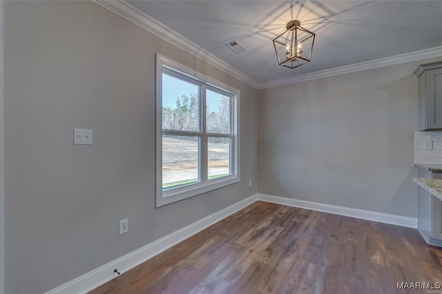 unfurnished dining area with crown molding, dark hardwood / wood-style flooring, and a notable chandelier