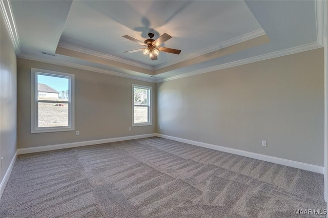 unfurnished room with ceiling fan, carpet flooring, a tray ceiling, and crown molding