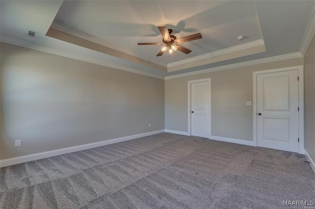 carpeted spare room with a raised ceiling and crown molding