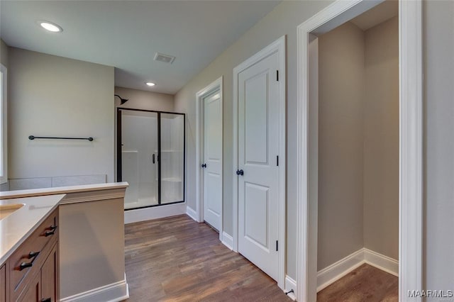 bathroom featuring vanity, hardwood / wood-style floors, and walk in shower