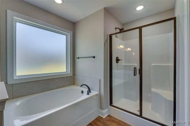 bathroom with hardwood / wood-style floors, plus walk in shower, and a wealth of natural light