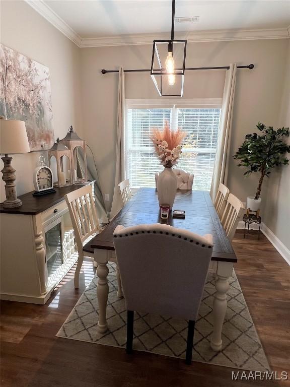 dining area with crown molding and dark wood-type flooring