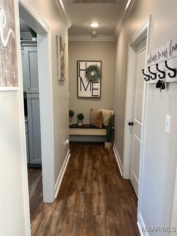 corridor featuring ornamental molding and dark wood-type flooring