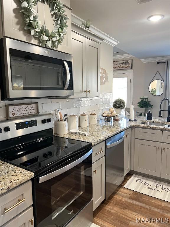 kitchen featuring gray cabinets, sink, backsplash, dark hardwood / wood-style flooring, and stainless steel appliances