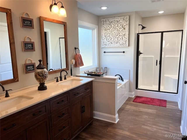 bathroom featuring hardwood / wood-style flooring, vanity, and plus walk in shower