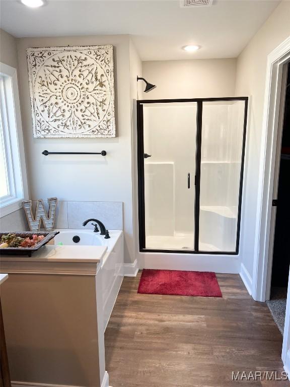 bathroom featuring separate shower and tub and hardwood / wood-style floors