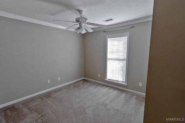 carpeted spare room with ceiling fan and ornamental molding