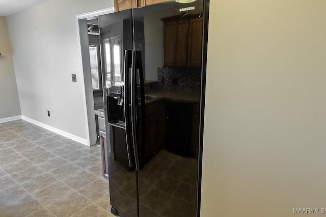 kitchen featuring black refrigerator with ice dispenser and light tile patterned flooring