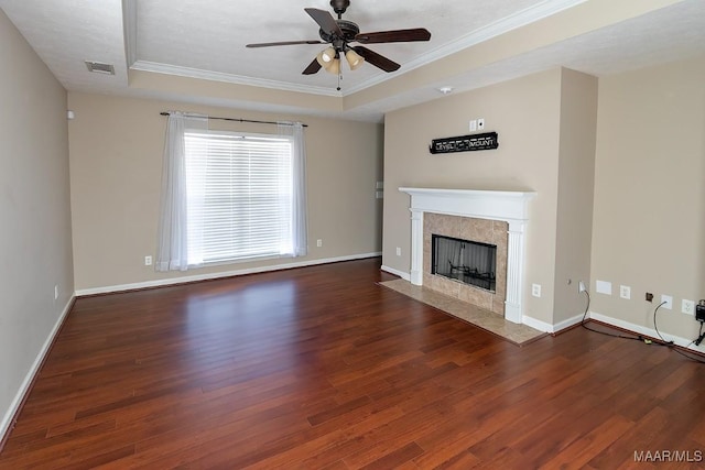 unfurnished living room featuring dark hardwood / wood-style floors, a premium fireplace, a raised ceiling, and ceiling fan