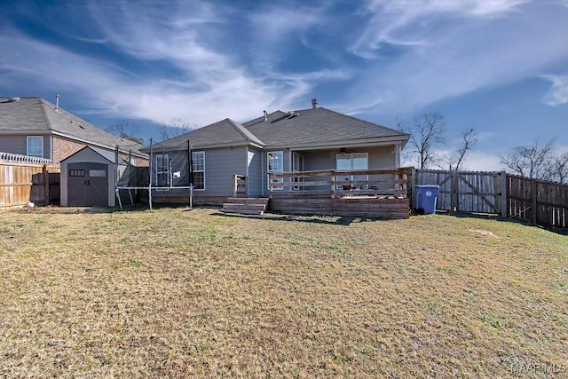 rear view of property featuring a shed and a yard