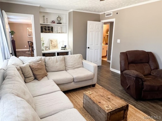 living room with a textured ceiling, crown molding, built in features, and hardwood / wood-style flooring