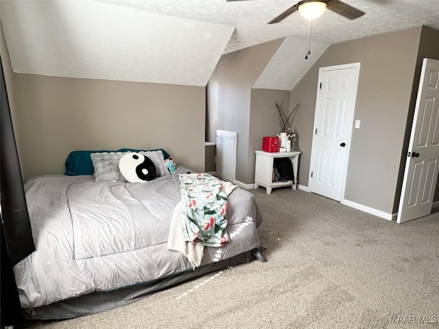 carpeted bedroom featuring ceiling fan, vaulted ceiling, and a textured ceiling