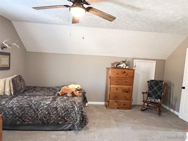 bedroom featuring a textured ceiling, ceiling fan, carpet, and lofted ceiling