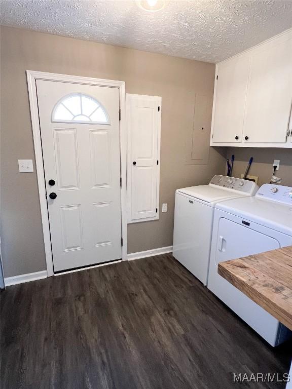 laundry area featuring a textured ceiling, cabinets, washer and clothes dryer, and dark wood-type flooring