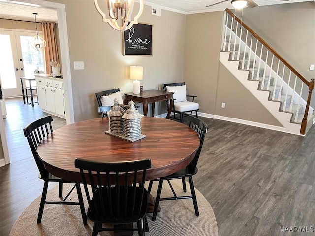 dining space with dark hardwood / wood-style floors, a chandelier, crown molding, and french doors