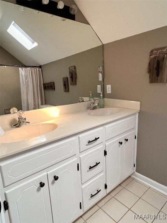 bathroom featuring lofted ceiling, vanity, and tile patterned flooring