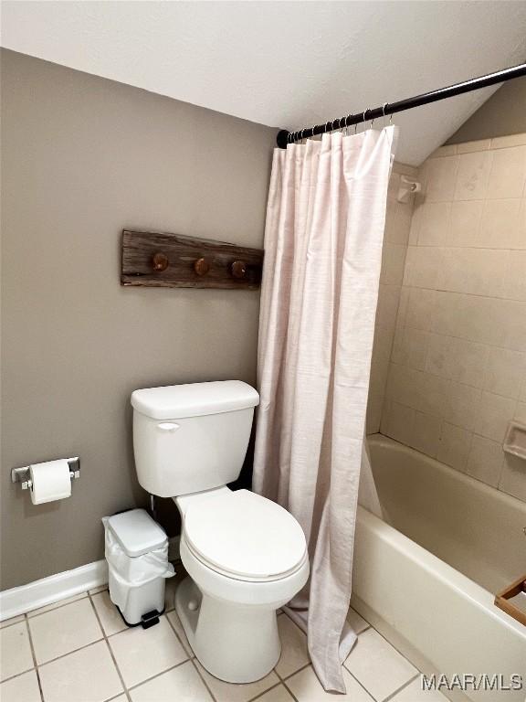 bathroom featuring toilet, shower / bathtub combination with curtain, and tile patterned floors