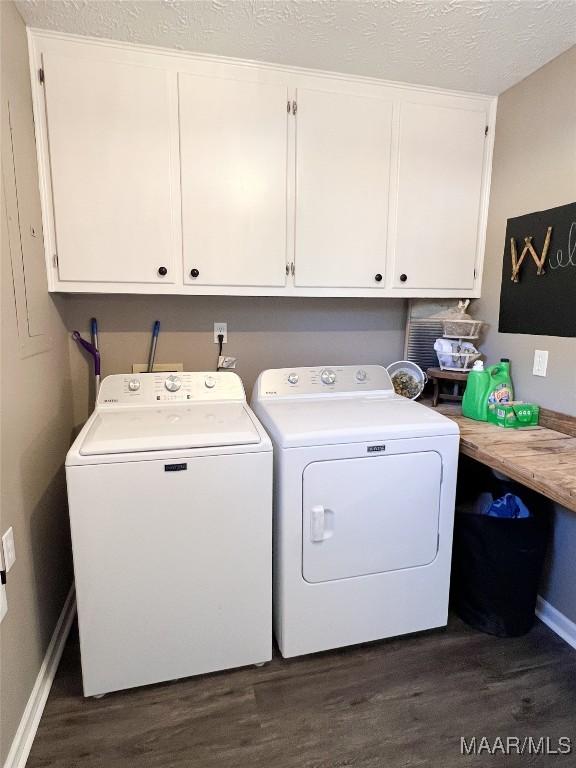 washroom with dark hardwood / wood-style flooring, separate washer and dryer, a textured ceiling, and cabinets