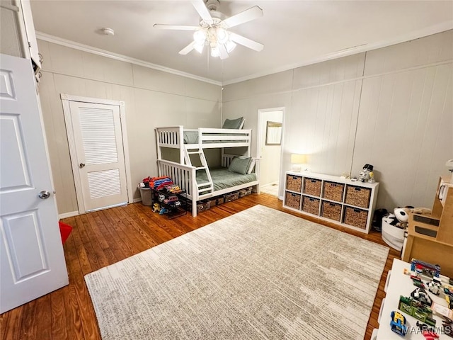 bedroom featuring ceiling fan, dark hardwood / wood-style flooring, a closet, and ornamental molding