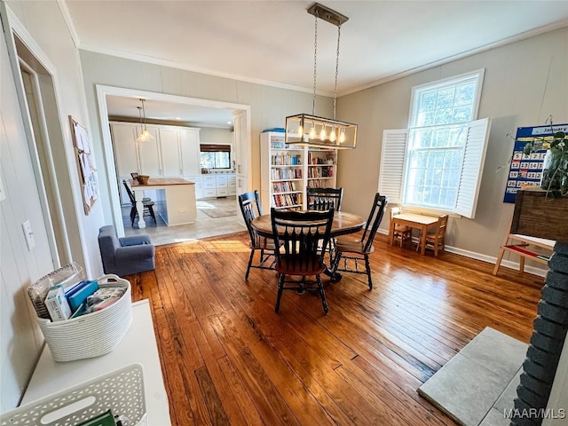 dining room featuring ornamental molding, a chandelier, and hardwood / wood-style floors