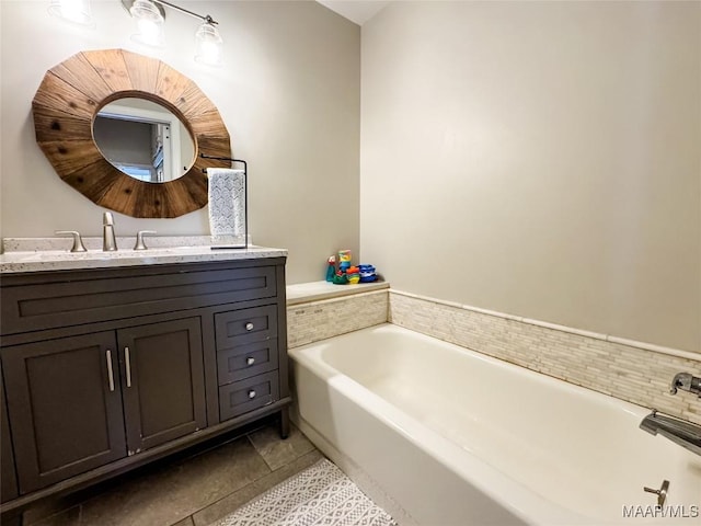 bathroom featuring a tub to relax in, vanity, and tile patterned flooring