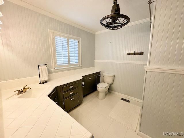 bathroom featuring toilet, vanity, ornamental molding, and tile patterned flooring