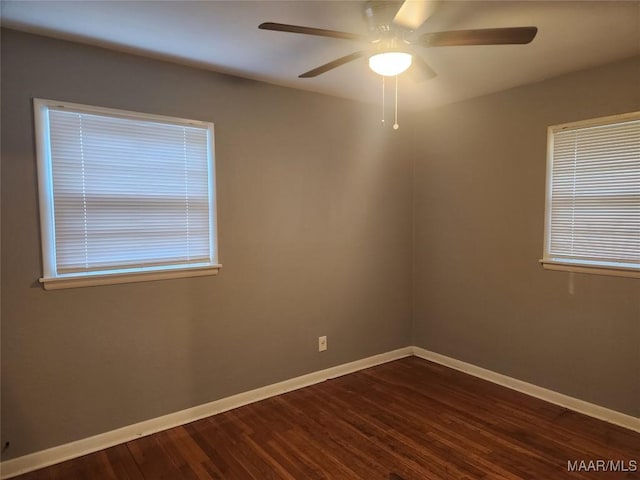 unfurnished room with ceiling fan and dark wood-type flooring