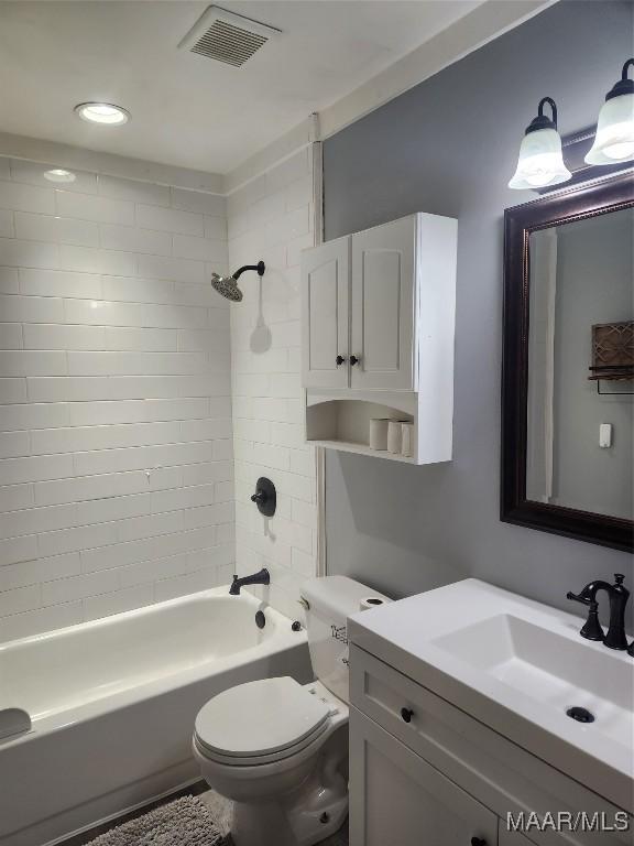 full bathroom with toilet, tiled shower / bath combo, and vanity