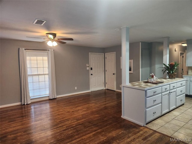 kitchen with ceiling fan, ornate columns, and light hardwood / wood-style floors