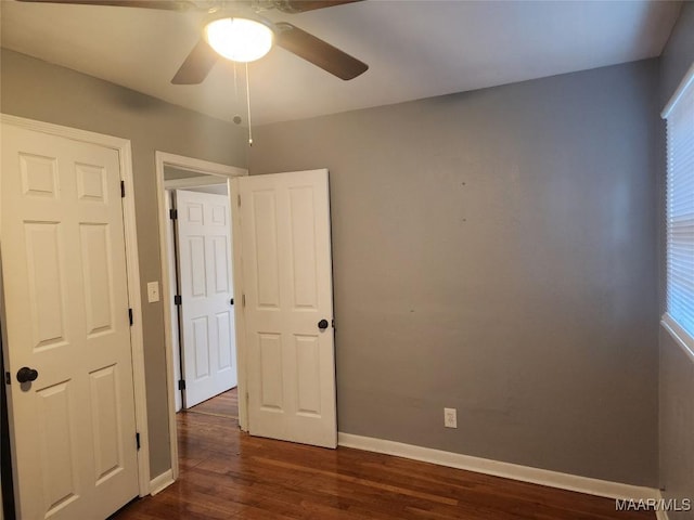 unfurnished room with ceiling fan and dark hardwood / wood-style floors